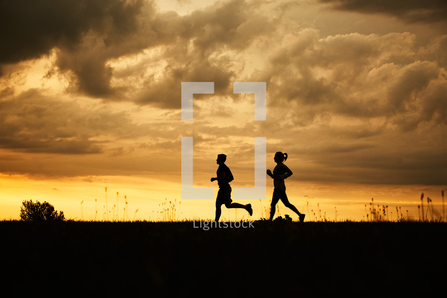 silhouettes of a couple running together 