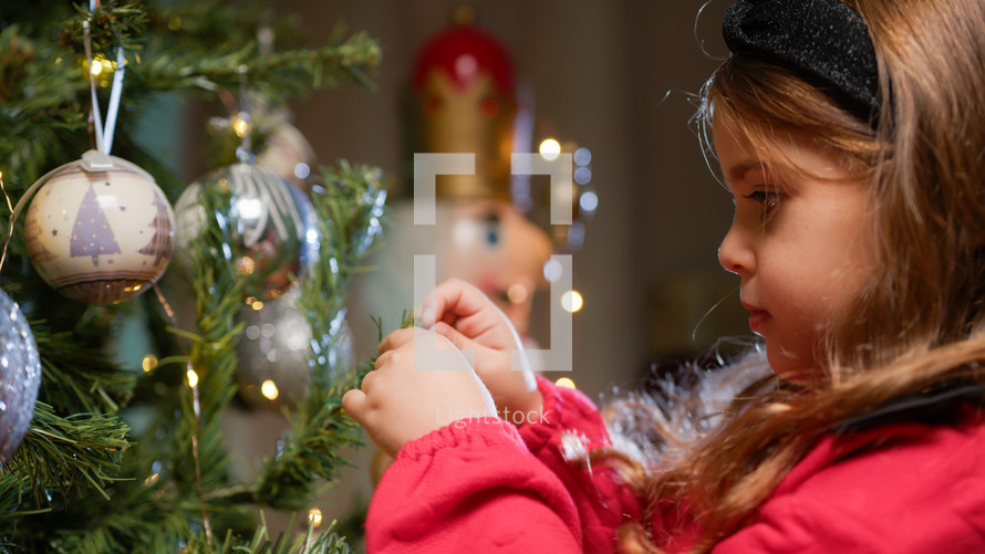 Little Girl decorating Christmas tree