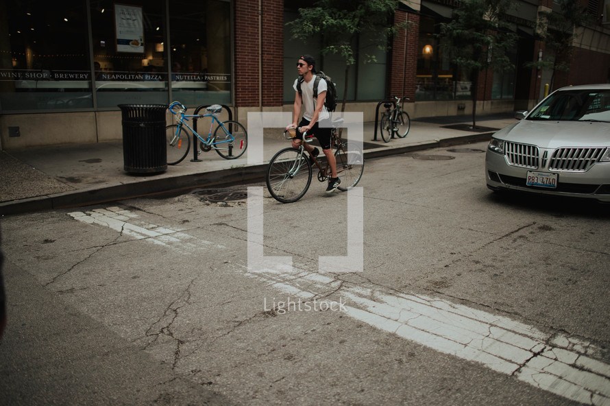 A young man riding a bicycle on a city street.