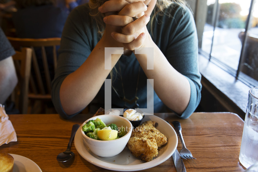 woman praying before a meal 