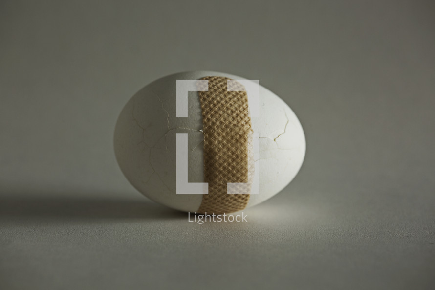 bandage around a cracked egg.