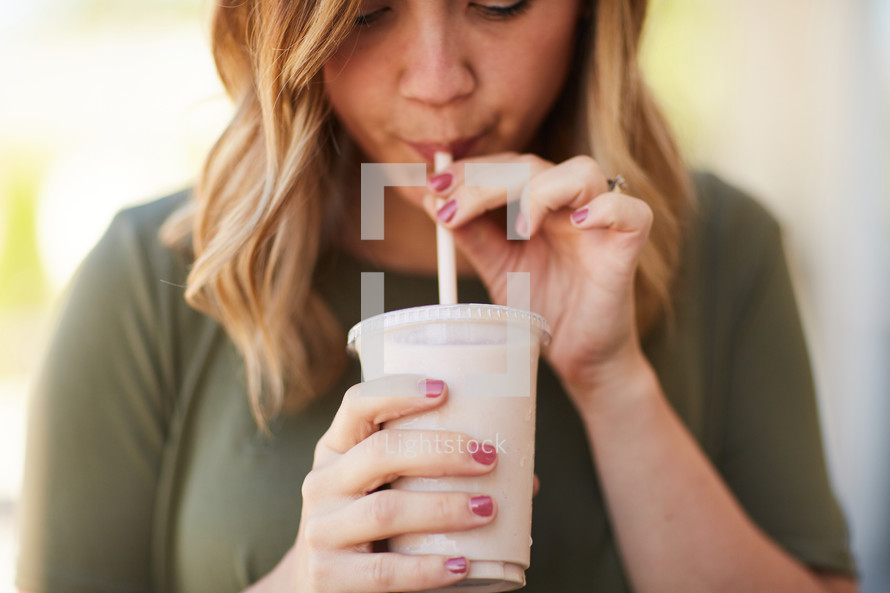 a woman drinking a smoothie 