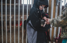 a boy holding a baby piglet 