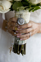 bride holding a bouquet and a rosary