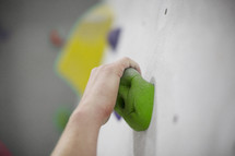 hand reaching onto a climbing wall grip 