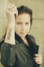 woman with a tattoo of the word forgiven 