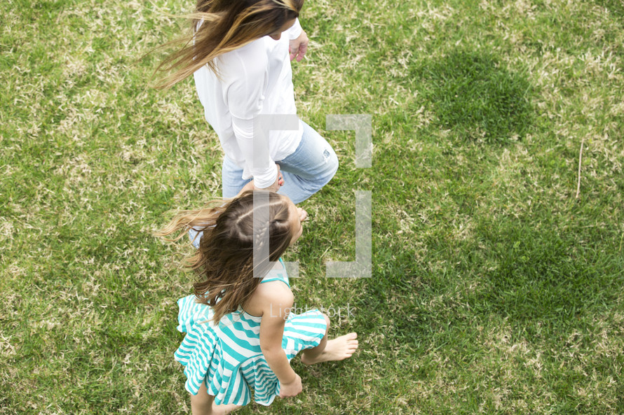 mother and daughter walking holding hands outdoors 