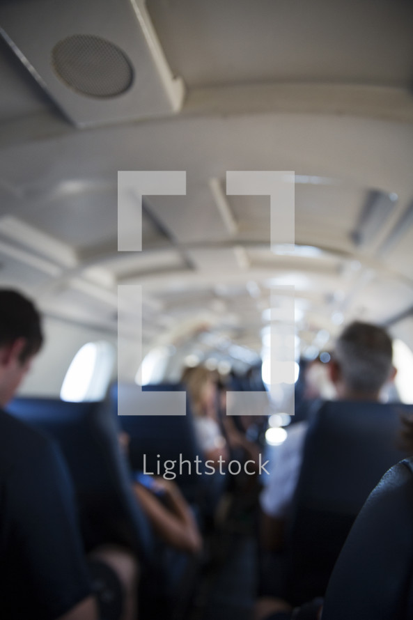 blurred people sitting on an airplane.