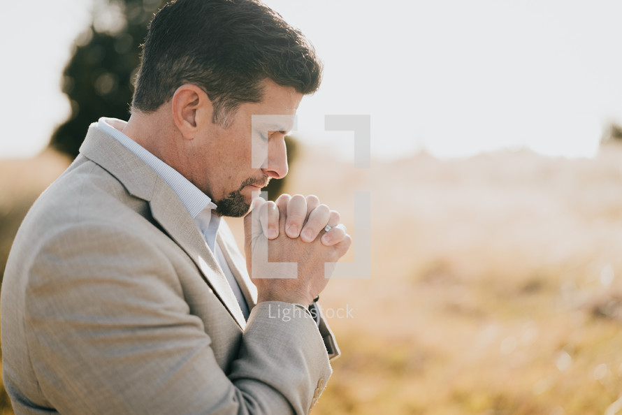 a man praying in a field 