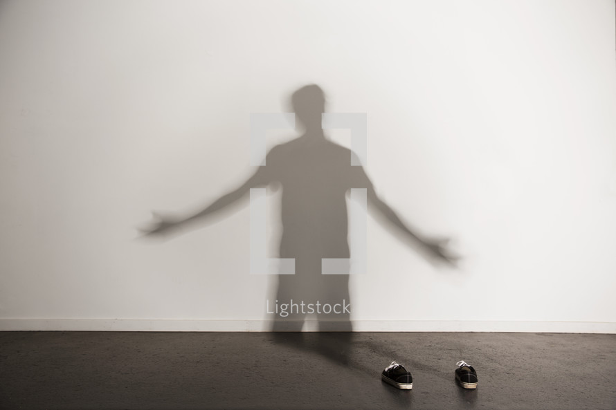shadow of a man with open arms praising God 