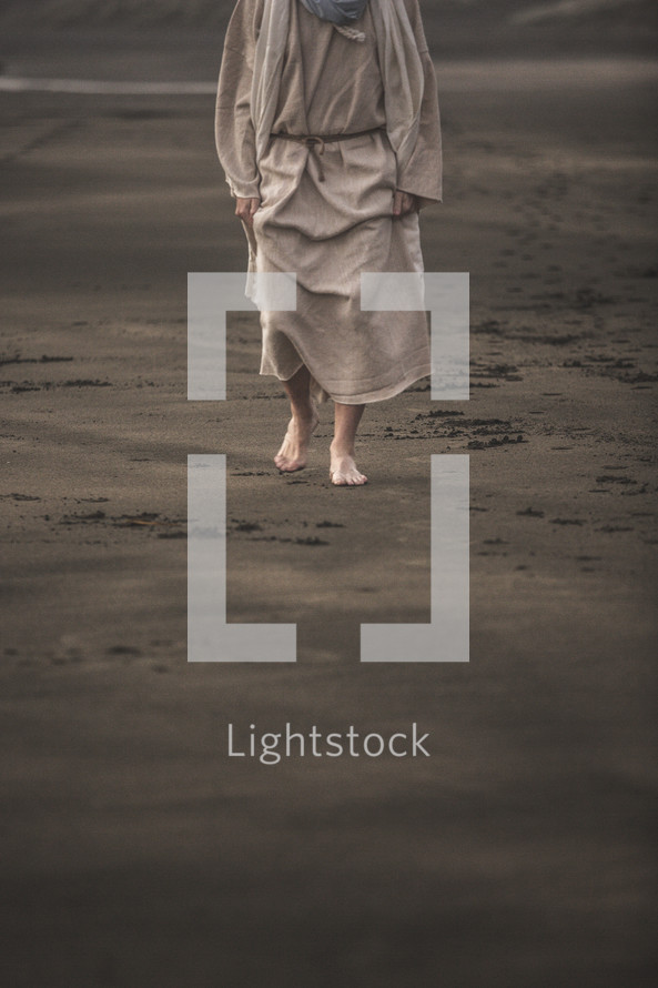 Jesus walking barefoot on a beach 