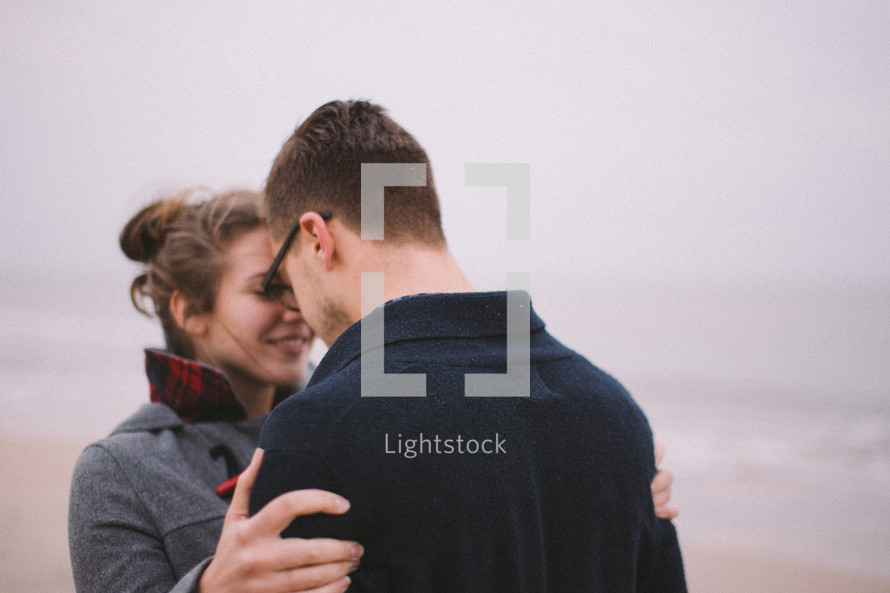 a man kissing a woman on a beach 