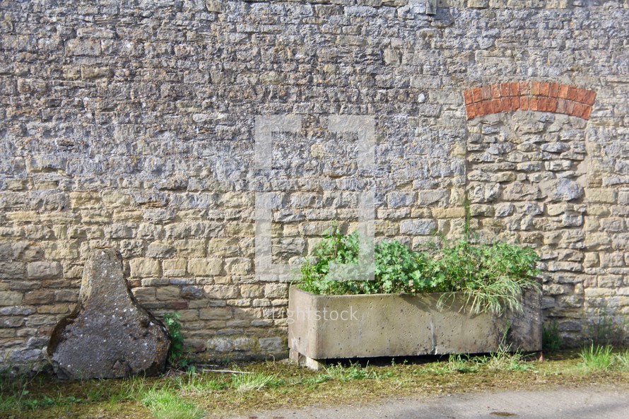 planter box in front of a stone wall 