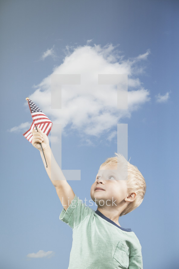 little boy holding an American flag up