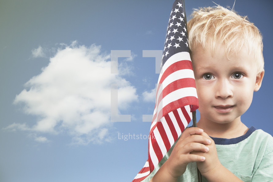 little boy holding an American flag