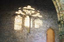 sunlight through church windows on a stone wall 