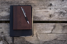 pen on a journal and Bible 