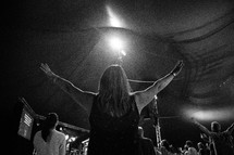 A woman with her arms raised during a church service.