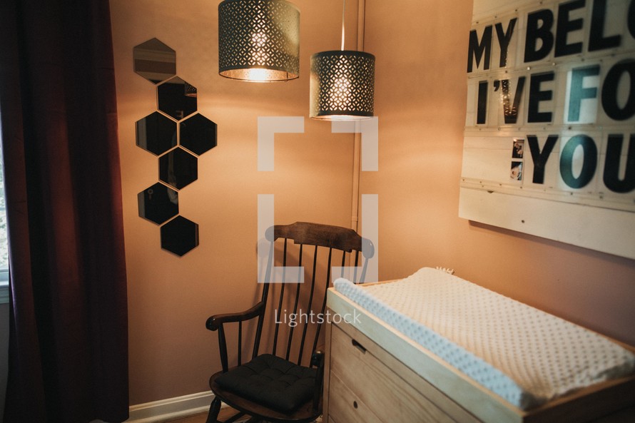 chair in a corner and changing table in a nursery 