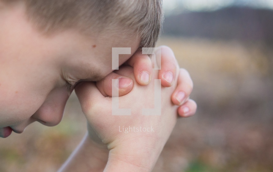 close up of boy praying.