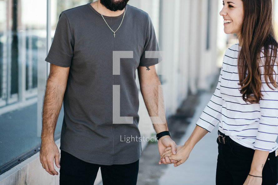 couple on a sidewalk holding hands 