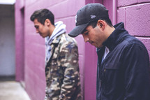 two men standing in an alley looking down 