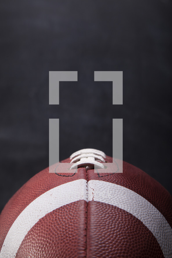 close up of an American football with a chalkboard background. 