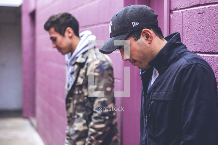 two men standing in an alley looking down 