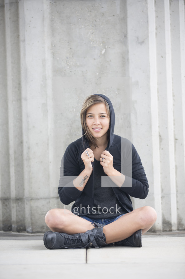 woman sitting wearing a hoodie 