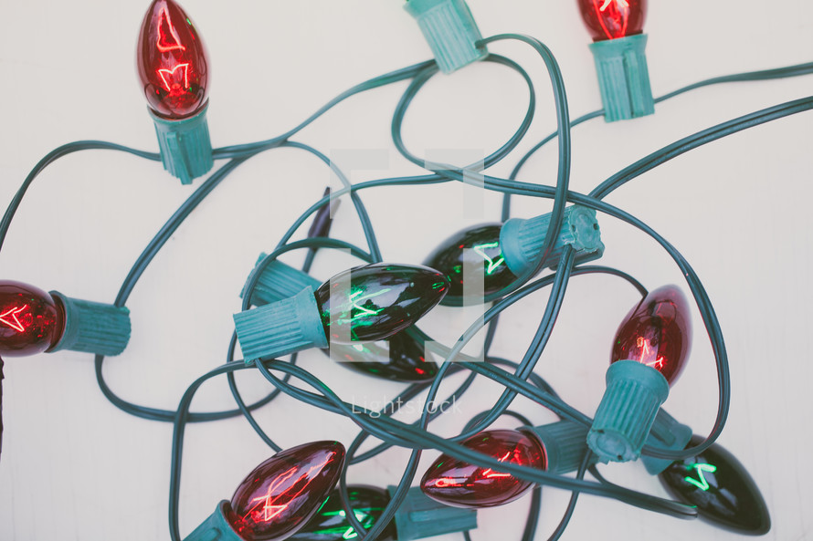 A bundle of red and green Christmas lights on a white background.