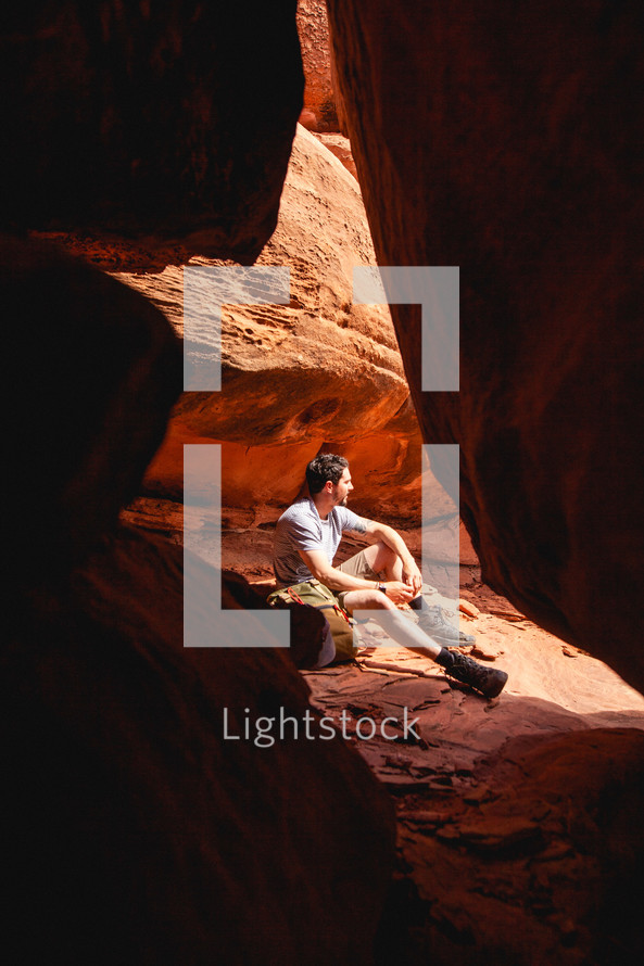 a man sitting on red rocks 