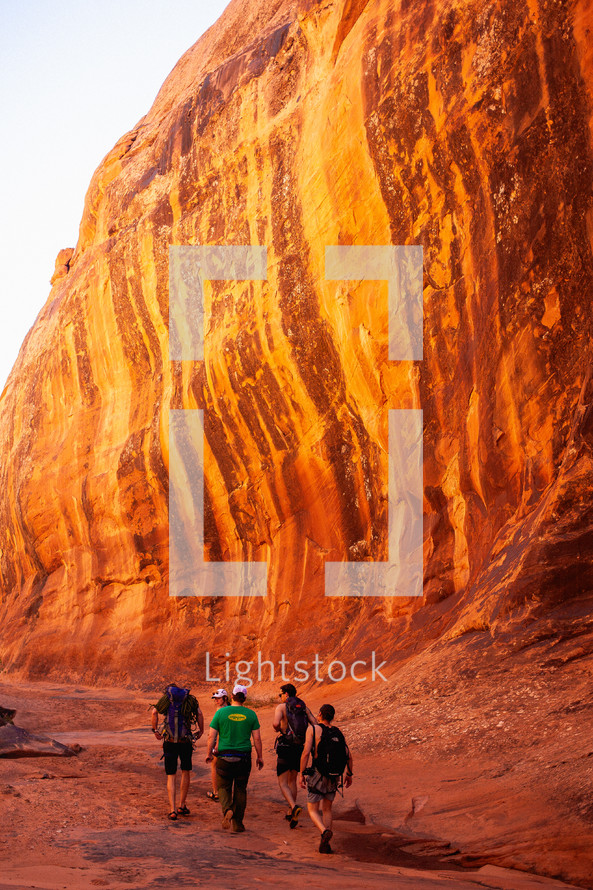 people hiking through a red rock canyon 