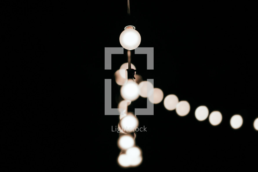 hanging lightbulbs in darkness 