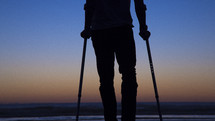 silhouette of a crippled man in arm braces