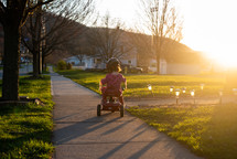 toddler girl riding a tricycle 