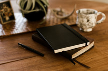 A Bible and journal on a table 