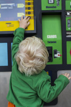 toddler boy at a ticket machine 