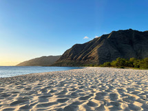 Empty Beach in Oahu, Hawaii with Lush Green Mountains in the Background