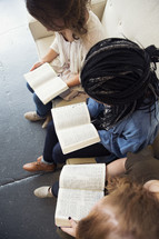 young women sitting on a couch reading bibles 