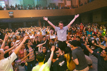 standing with raised hands at a worship service 