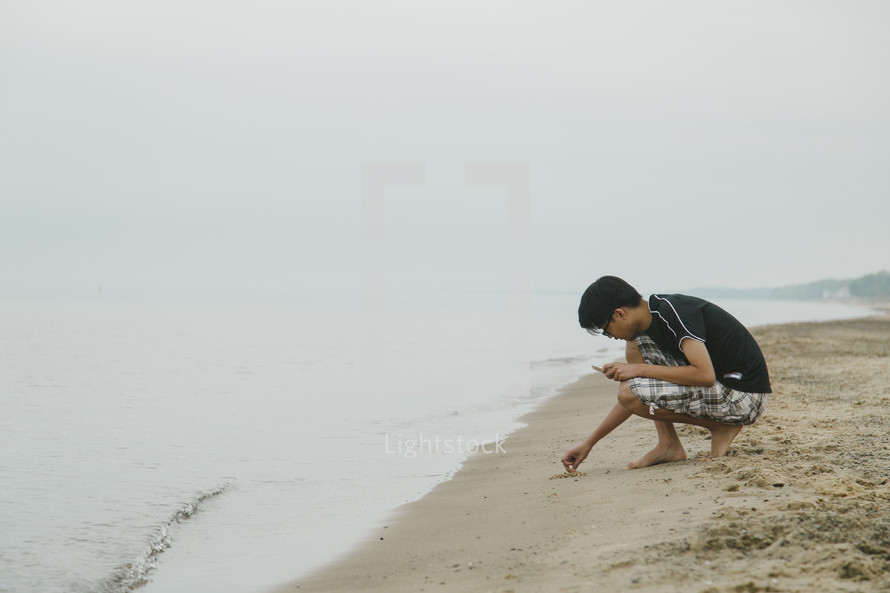 young man playing in the sand on a beach 