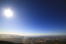 A sunburst over a mountain range. 