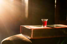 bright sunlight and communion cup on a Bible 