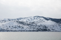 snow on a mountains beside a lake 