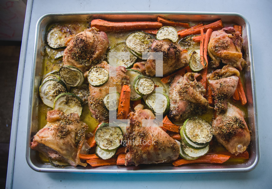 baked chicken and vegetables in a pan 