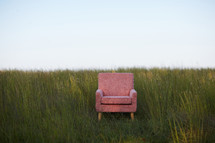 empty chair in a field of tall grasses 