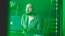 a stage production crew member behind a laptop computer screen 