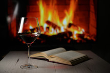 Dry Glass Of Red Wine, on Book and Fireplace in Background