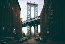 view of the Brooklyn Bridge through an alley 