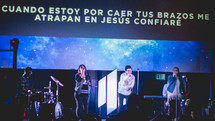 Spanish on a projection screen behind worship leaders 